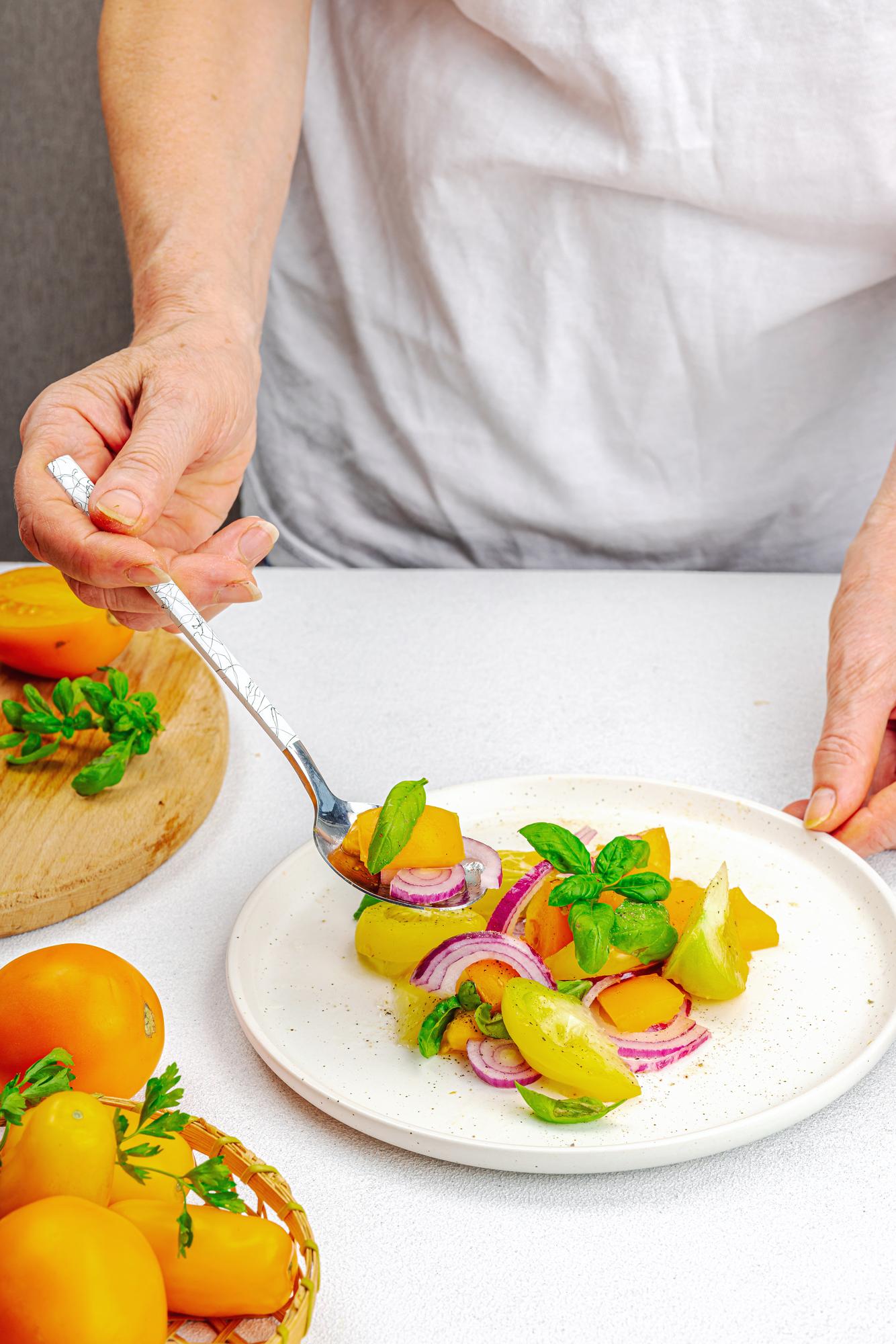 Chef hands finishing a main course under studio light